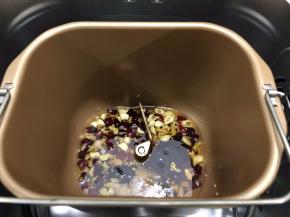 面包机桶内倒入花生油启动翻炒干果功能，等到面包机开始翻炒，倒入辣椒，蒜头，姜先翻炒8分钟