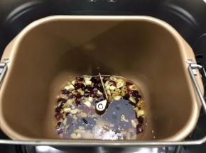 面包机桶内倒入花生油启动翻炒干果功能，等到面包机开始翻炒，倒入辣椒，蒜头，姜先翻炒8分钟