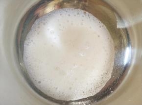 开始打发蛋白。打至粗泡后加入三分之一细砂糖