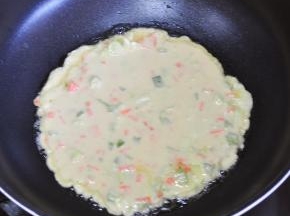 油热后倒入面糊，尽量整成圆形。