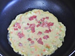 将培根撒上，小火慢慢煎，煎至表面基本凝固。