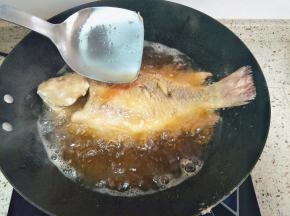 一面炸定型翻面，一边炸一边往鱼身上浇油