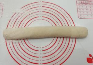 揉面垫洒点手粉，把面团滚成圆条状；