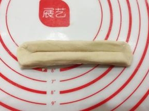 然后两头捏紧捏扁，顺势把面块拉伸长一些；