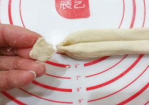 捏紧实后再顺势揪下一点面块，这样炸的时候两头就不会散开了；