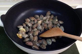 倒入清洗沥干水后的花蛤，翻炒片刻。