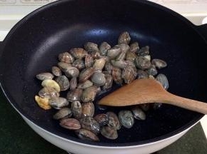 倒入清洗沥干水后的花蛤，翻炒片刻。