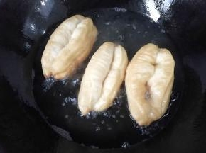 锅中入适量油，七八成热时放入油条胚炸制，其间要用长筷子不停的翻拨哈。炸至金黄色后捞起控油即成；