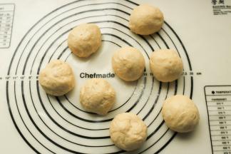 发酵好的面团移到揉面垫上，排气后分成8份，再滚圆松弛15分钟。