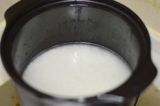 4，砂锅洗净后，用刷子蘸取少量油，刷满整个砂锅。将浸泡过的米，放入锅中，加入适量水，盖上盖子，大火烧开。