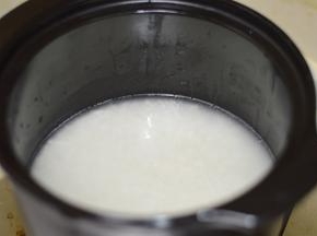 4，砂锅洗净后，用刷子蘸取少量油，刷满整个砂锅。将浸泡过的米，放入锅中，加入适量水，盖上盖子，大火烧开。