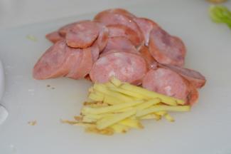 2，香肠如果是冷冻的，提前解冻后最好用水煮一下，姜切成丝备用。