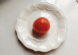 番茄一个表皮画十字，然后用开水烫一会儿，再剥掉外皮；