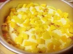 平铺在'之前的饼干底上后再把三分之一的芒果丁铺在上面，第二层酸奶芝士慕斯就做好了，放冰箱冷藏备用