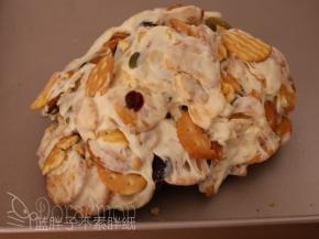 之后把它们移到金盘上，戴上手套，趁热不断地折叠翻转几次，使得糖包裹住所有材料。