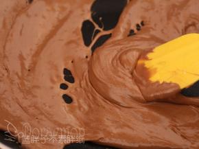 不断画圈圈混匀。加入奶粉和可可粉混合物，拌匀。