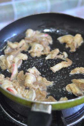 锅里倒入油，放入肉片炒至变色。