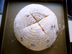 将面团倒扣在烤盘，在圆形面团表面割十字