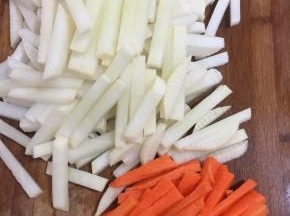 把白萝卜和胡萝卜切成筷子粗细的条儿。（萝卜条不要切的太粗，否则入味儿慢。）