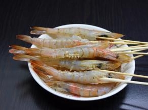 用烧烤签把虾串起来，放盐、姜粉、胡椒粉腌制10分钟；