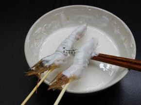 裹炸粉加适量的水拌均成浆糊，均匀裹在虾身上；