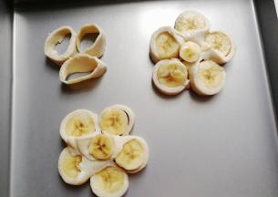 再借用刮板把它移到烤盘中，中间再摆入先前去掉的香蕉边角，飞饼边角也放进去烤一烤；