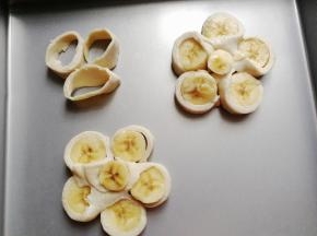 再借用刮板把它移到烤盘中，中间再摆入先前去掉的香蕉边角，飞饼边角也放进去烤一烤；