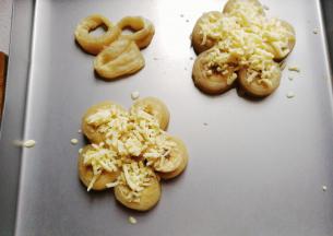 放入预热好的烤箱中层上下火180度先烤七八分钟，然后取出洒上适量芝士碎，再继续烤四五分钟即好；