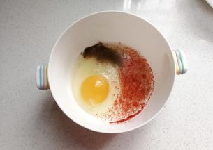 鸡蛋一个打入碗中，再调入适量盐、料酒、胡椒粉和辣椒粉搅拌均匀；