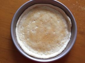 擀出饼皮放入披萨盘中，用叉子叉上小洞，这样避免烘烤时饼皮膨胀，刷上蜂蜜