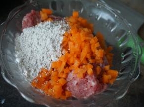 然后把剁好的猪肉放入碗里加入薯粉和切丁的胡萝卜搅拌均匀