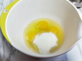将鸡蛋敲深一点的器具中，加入白砂糖。