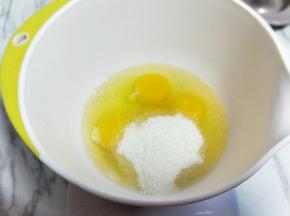 将鸡蛋敲深一点的器具中，加入白砂糖。
