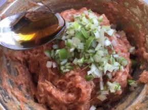 放入葱花，在葱花上淋上1勺香油，用香油裹住葱花，锁住葱汁，然后再朝一个方向继续搅拌均匀。