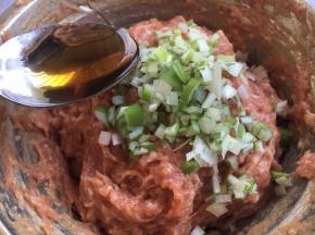 放入葱花，在葱花上淋上1勺香油，用香油裹住葱花，锁住葱汁，然后再朝一个方向继续搅拌均匀。