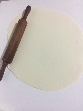 用擀面杖擀成2毫米左右的面片。（如果面团太大，案板太小，可以把面团分成两份，一份用保鲜膜包住，擀完一份再擀另外一份面团。）