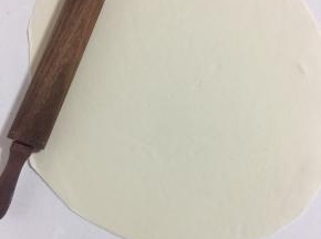 用擀面杖擀成2毫米左右的面片。（如果面团太大，案板太小，可以把面团分成两份，一份用保鲜膜包住，擀完一份再擀另外一份面团。）