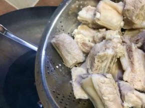 放入排骨用油煎炒，排骨炒制变色稍微焦化