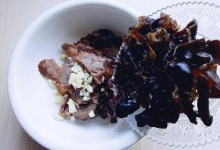 将木耳撕小块，倒入装牛肉的器具里。