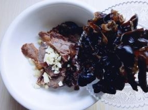 将木耳撕小块，倒入装牛肉的器具里。