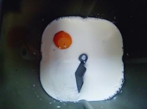 首先将牛奶倒入面包桶，再加入鸡蛋，糖和盐对角放。