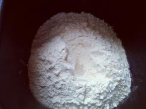 最后放入面粉，再面粉顶端挖个小洞，注意不要挖到液体。把酵母粉放入洞里，再用周边的面粉把酵母粉盖起来。