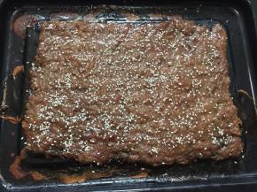 然后取出猪肉脯，撕掉另一层油纸，刷上蜂蜜水，撒上白芝麻，回炉继续烤10分钟