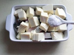 把豆腐盖在鱼的上面，盐均匀撒上去