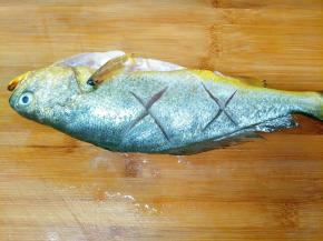 黄瓜鱼处理干净鱼鳞、内脏，用刀在表面划两刀方便入味