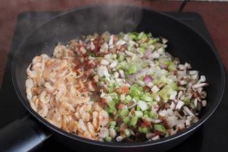 加入腊肠、香菇、葱白继续翻炒；