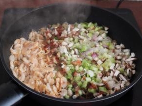 加入腊肠、香菇、葱白继续翻炒；