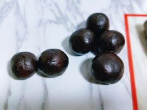 取一块豆沙馅，将蛋黄包起来，豆沙蛋黄馅包起来，如图。