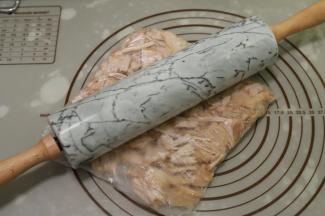 捞出肉块沥干水分，放凉后装入保鲜袋，用擀面杖压扁