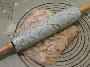 捞出肉块沥干水分，放凉后装入保鲜袋，用擀面杖压扁